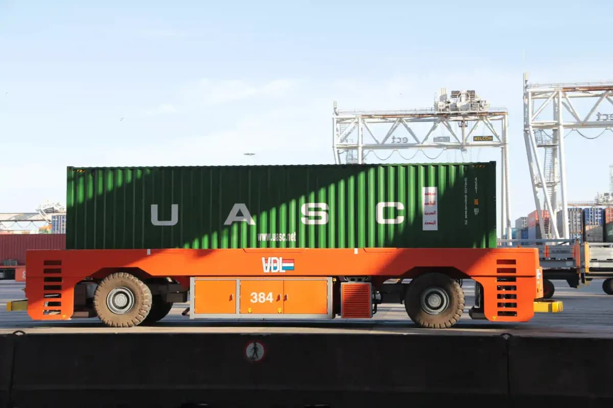 A flat-bed truck delivering a shipping container