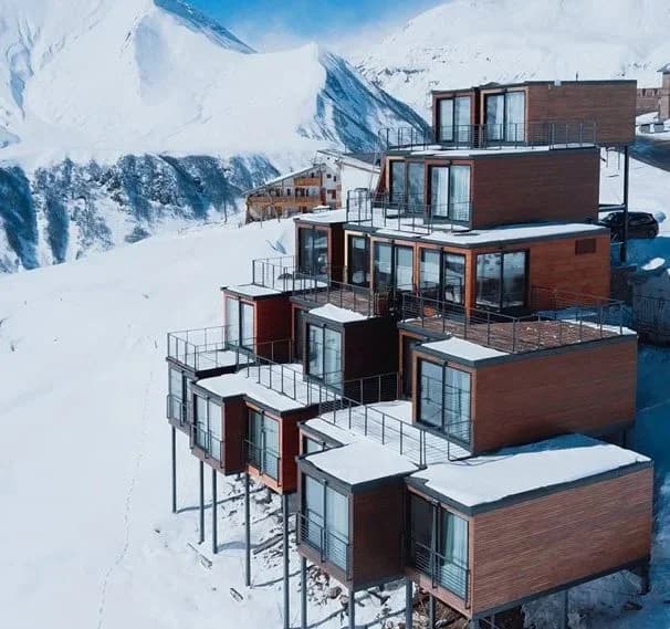 Shipping containers used as boutique hotel accommodations on a snowy mountainside