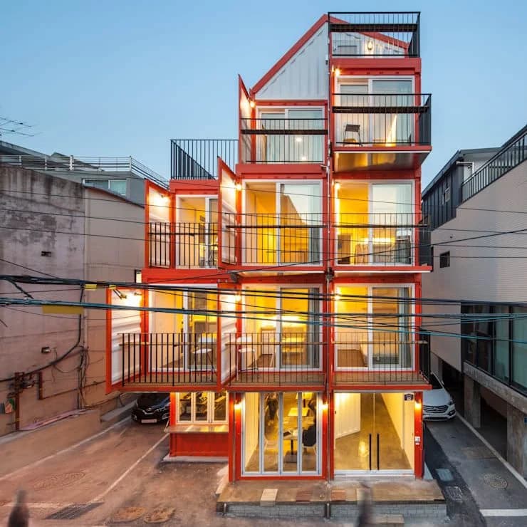 Multi-story orange shipping container building used as boutique accommodations
