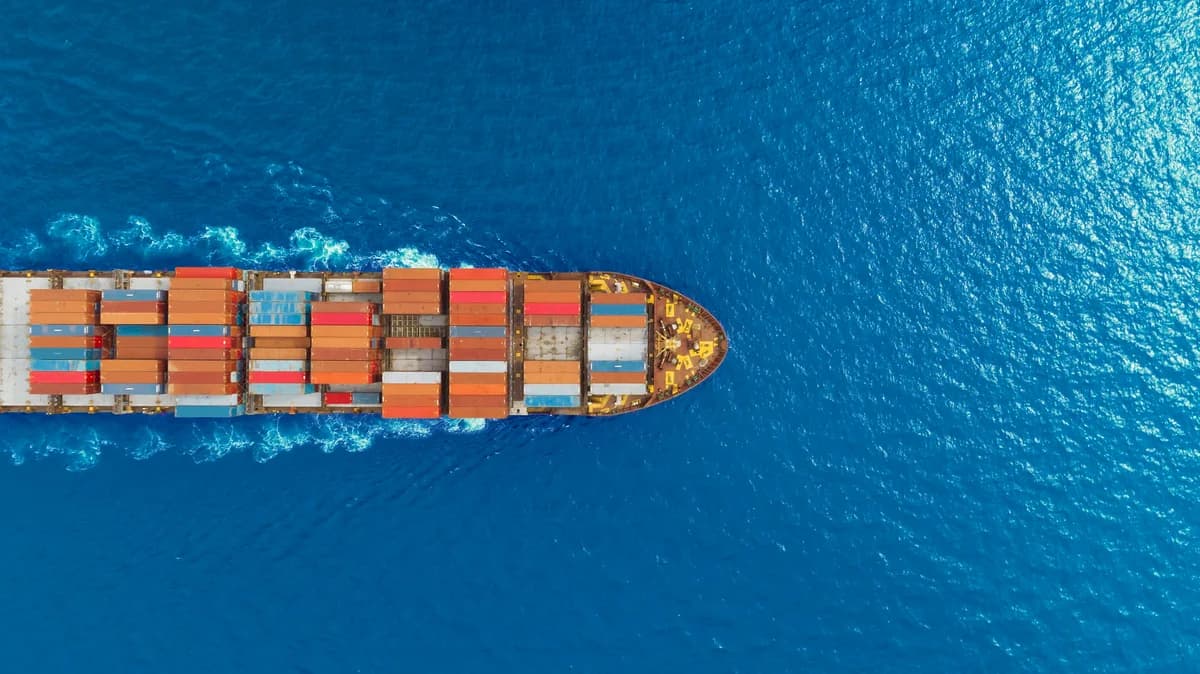 Aerial view of a cargo ship loaded with shipping containers crossing the open sea