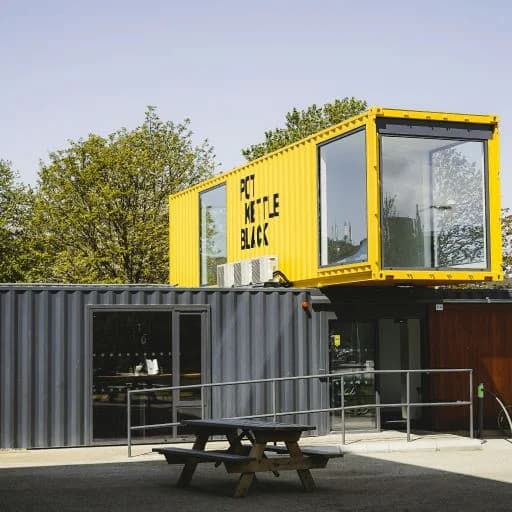Yellow shipping container converted into a Pet Bottle Black retail storefront