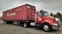 Truck arriving with a shipping container.