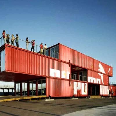 Red shipping containers stacked into a multi-story PUMA retail storefront