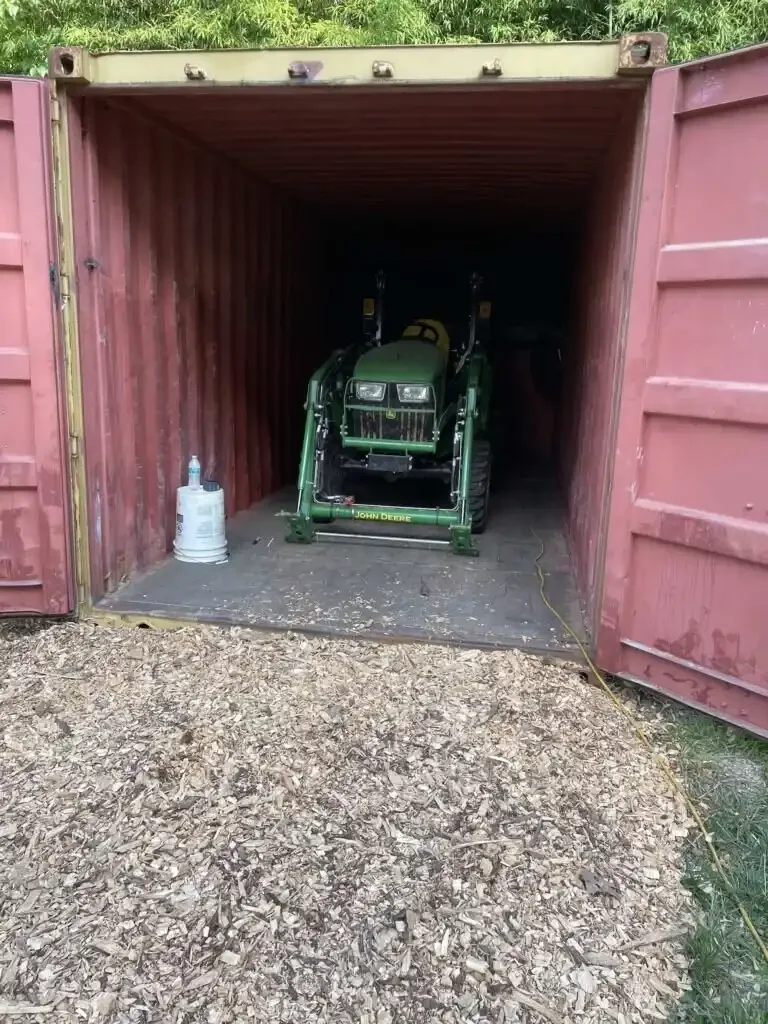 A tractor storaged in a wind-and-watertight shipping container.